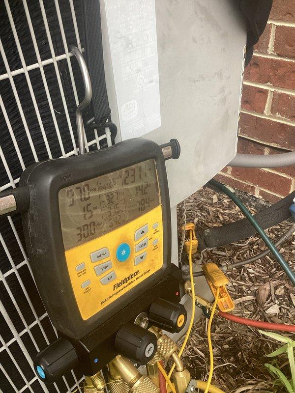 # Summary

Completed routine air conditioner maintenance on a 14-year-old central AC system for a maintenance plan member, with all components operating within normal parameters.

# Work Performed

Performed comprehensive preventive maintenance on outdoor condensing unit positioned on exterior brick wall. Conducted visual inspection of condenser cabinet, housing, and protective grille, confirming structural integrity and proper clearances. Verified electrical disconnect box mounting and functionality.

Connected Fieldpiece digital manifold gauge set to service ports to evaluate system performance. Recorded refrigerant pressures and temperatures on both high and low sides of the system. Analyzed superheat and subcooling values to assess proper refrigerant charge levels. All readings indicated system is operating within manufacturer specifications.

Inspected condenser coil fins for debris, damage, and airflow restrictions. Examined fan motor operation, blade condition, and bearing integ