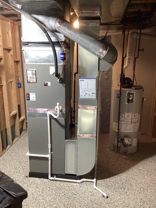 Completed installation of 110,000 BTU high-efficiency furnace unit (model SLP99UH110XV8DCK-01) in basement mechanical room. Installed new furnace with metallic supply ductwork extending from unit plenum, properly secured all connections, and verified nameplate attachment on blower access panel. Obtained necessary mechanical permits prior to installation and documented completed work with site photographs showing furnace positioned adjacent to existing water heater with proper clearances maintained.