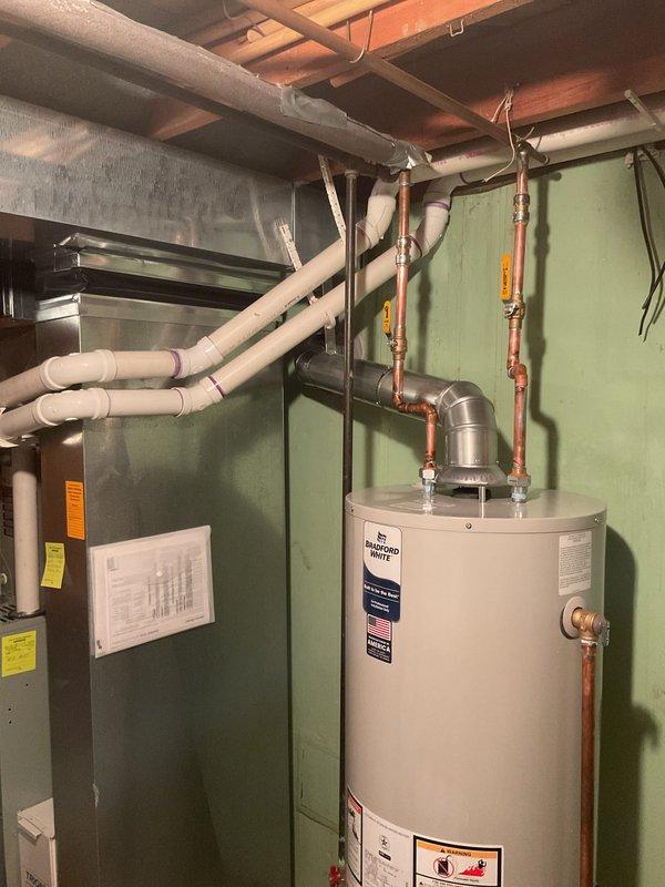 Successfully installed a 40-gallon tanked water heater in the residential mechanical room. Connected all copper supply and discharge lines to the unit top, installed pressure relief valve with proper drainage, and verified all gas line connections. Established proper venting through existing flue system and confirmed all safety labels and specifications are visible and compliant with code requirements.