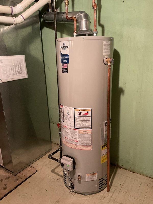 Successfully installed a 40-gallon tanked water heater in the residential mechanical room. Connected all copper supply and discharge lines to the unit top, installed pressure relief valve with proper drainage, and verified all gas line connections. Established proper venting through existing flue system and confirmed all safety labels and specifications are visible and compliant with code requirements.