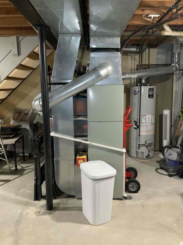Conducted full system evaluation for 881 square foot townhouse condo with 15-year-old furnace and air conditioning system. Customer reported excessive airflow velocity, inadequate dehumidification due to short cycling, and incompatible aftermarket blower motor causing furnace overheat protection issues when adjusted. Inspected basement mechanical room installation including furnace cabinet, ductwork, and AC components. Documented ductwork expansion noise occurring at cycle termination. Assessed current equipment configuration with mismatched blower motor replacement limiting system adjustability. Photographed existing HVAC installation showing furnace unit with metallic ductwork, water heater, and basement utility area layout. Provided comprehensive replacement estimate for complete furnace and air conditioning system to address airflow control, humidity management, and equipment compatibility concerns in attached dwelling with limited exterior exposure.