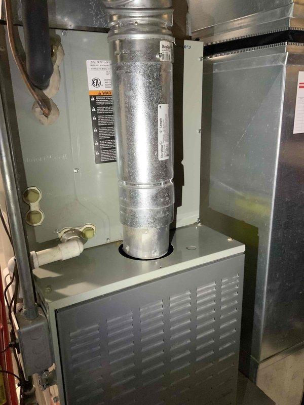 Conducted full system evaluation for 881 square foot townhouse condo with 15-year-old furnace and air conditioning system. Customer reported excessive airflow velocity, inadequate dehumidification due to short cycling, and incompatible aftermarket blower motor causing furnace overheat protection issues when adjusted. Inspected basement mechanical room installation including furnace cabinet, ductwork, and AC components. Documented ductwork expansion noise occurring at cycle termination. Assessed current equipment configuration with mismatched blower motor replacement limiting system adjustability. Photographed existing HVAC installation showing furnace unit with metallic ductwork, water heater, and basement utility area layout. Provided comprehensive replacement estimate for complete furnace and air conditioning system to address airflow control, humidity management, and equipment compatibility concerns in attached dwelling with limited exterior exposure.