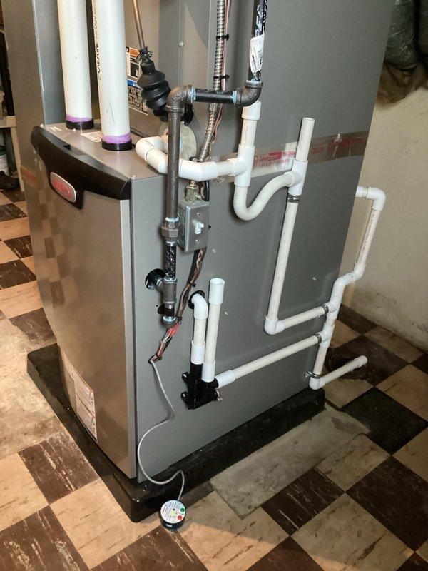 Completed full HVAC system installation including 70,000 BTU furnace and 2.5 ton air conditioning unit with rear discharge configuration. Installed complete PVC drainage and condensate system with proper pitch and connections, black iron gas piping with shutoff valve, flexible gas connector, and electrical connections with junction box. Reconnected existing humidifier to new system and mounted all equipment on appropriate drain pan in basement utility area. All mechanical, electrical, and furnace permits obtained and installation performed to code specifications.