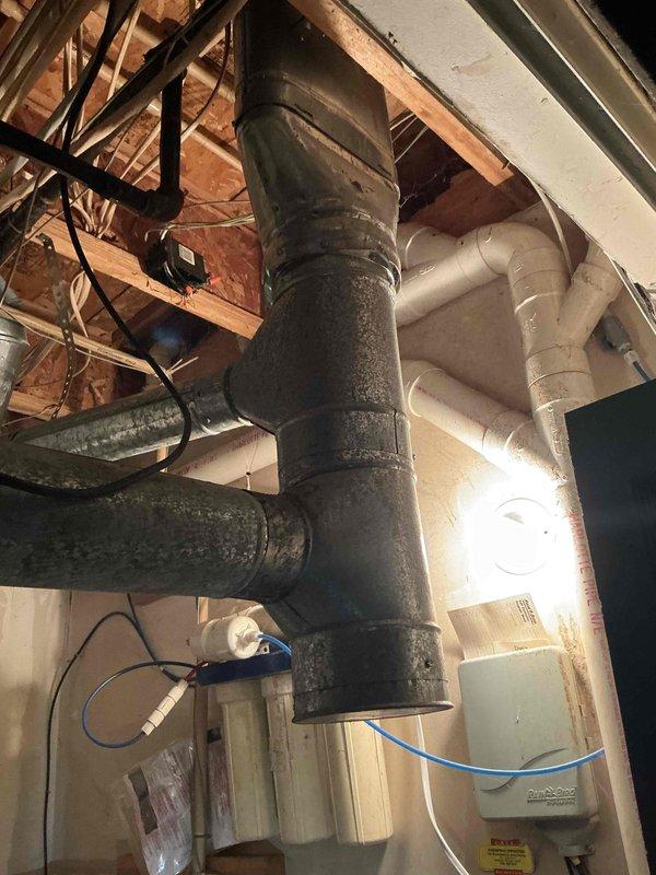 Conducted comprehensive evaluation of 26-year-old air conditioning system experiencing intermittent shutdown issues. Inspected existing Carrier furnace and AC installation in basement utility area, documenting extensive dust accumulation on ductwork, air handler components, and equipment surfaces. Assessed condition of flexible aluminum ductwork, gas line connections, and overall system infrastructure. Photographed existing HVAC configuration including main supply ducts, return air pathways, and equipment positioning for replacement planning purposes. Provided detailed estimate for complete AC system replacement due to age-related equipment failure and diminished reliability of current unit.