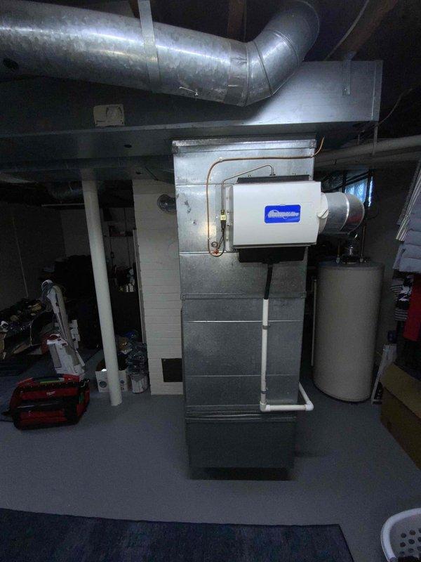 Conducted comprehensive assessment of inoperable 2010-2011 Bryant HVAC system in 750 square foot ranch home with full basement. Identified failed heat exchanger in 16-year-old Bryant furnace rendering unit unsafe for operation, along with aging air conditioning system of same vintage requiring replacement. Documented existing equipment configuration including air handler, ductwork, condensate pump assembly with PVC drainage system, and associated mechanical components. Photographed current installation showing metal ductwork distribution, copper refrigerant lines, electrical connections, and basement mechanical room layout to facilitate accurate full system replacement proposal for both heating and cooling equipment.