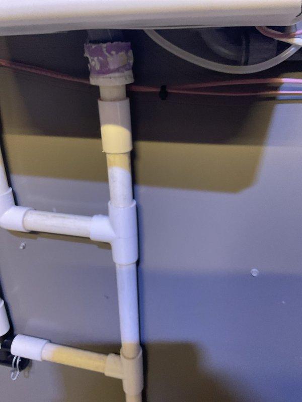 Responded to callback for steam humidifier drainage issue where water was overflowing due to improper drain configuration. Found existing installation using undersized 3/4" reducer with old bushing instead of required 1-1/2" drain pipe, preventing adequate drainage capacity. Corrected plumbing configuration to meet manufacturer specifications and ensure proper drainage function.