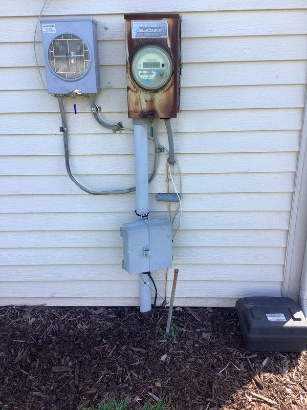 Completed HVAC install warranty inspection with focus on grounding and bonding recall verification. Documented water heater installation in basement utility area showing proper venting configuration with galvanized ductwork and associated piping connections. Inspected exterior electrical service panel, meter assembly, and conduit routing; noted existing rust staining on meter backing board requiring attention for proper system grounding integrity. Verified all mechanical connections, support structures, and electrical wiring pathways per manufacturer specifications and code requirements.