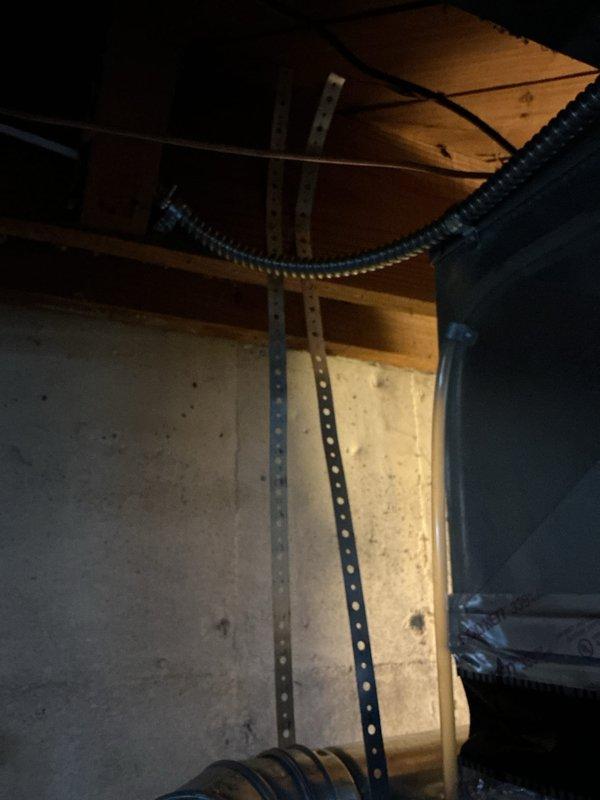 Responded to callback regarding possible chimney liner drop on recent HVAC installation. Upon inspection, verified proper installation and secure mounting of venting system through masonry wall penetration, confirmed all ductwork connections and support brackets are properly fastened and meeting code requirements. Documented current installation condition with photographs showing galvanized duct properly supported with metal strapping and wall-mounted structural supports, with no evidence of liner displacement or separation at chimney connection point.