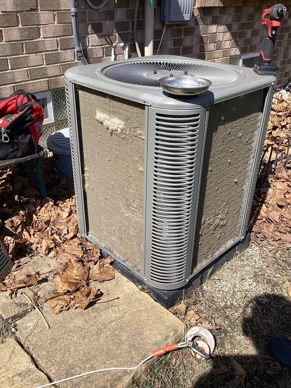 # HVAC Maintenance Summary

Completed scheduled ComfortGuard maintenance service on residential air conditioning system, performing comprehensive inspection and cleaning of outdoor condenser unit to ensure optimal cooling performance for the upcoming season.

# Work Performed

Performed preventive maintenance on outdoor air conditioning condenser unit positioned on concrete pad adjacent to brick structure. Conducted visual inspection of unit exterior, noting beige metal casing with vertical louvers in serviceable condition. Assessed fan grille and top-mounted components for proper mechanical integrity.

Cleared accumulated debris including dried leaves from perimeter of concrete pad and around base of condenser unit to ensure proper airflow and drainage. Removed organic material that had collected on and around equipment to prevent potential blockage of air intake passages.

Inspected electrical connections and conduit routing along adjacent wall structure. Verified secure mounting and