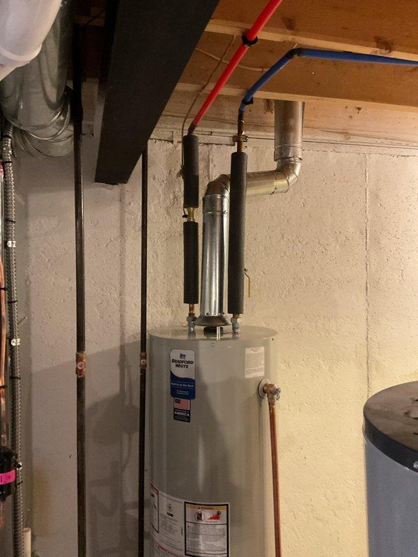 Installed a 40-gallon Bradford White tanked water heater in residential utility area with proper copper supply line connections, PEX piping integration, and code-compliant venting. Added drip pan beneath unit for leak protection and safety compliance. Reconnected all water supply lines, installed shut-off valves, and verified proper operation of the system upon completion.
