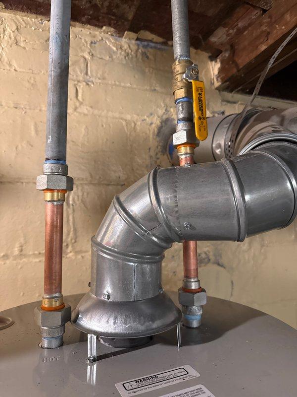Successfully installed a 40-gallon tanked water heater in basement utility area. Removed existing unit and installed new water heater with proper copper supply line connections, including hot and cold water piping with shutoff valves and dielectric unions. Connected temperature and pressure relief valve with discharge piping to code specifications. Installed flue vent piping for proper exhaust ventilation. All connections pressure tested and verified leak-free. Unit fired up and tested for proper operation, with temperature settings adjusted per manufacturer specifications. Permits were obtained prior to installation to ensure compliance with local mechanical codes. System fully operational upon completion with all safety features verified functional.