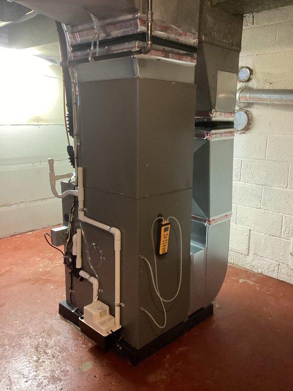 Completed full HVAC system installation including 70,000 BTU furnace and 2.5 ton air conditioning unit positioned on right side of property. Installed new condensate drain lines with PVC piping mounted to exterior brick wall with proper bracketing, connected to existing gutter system. Mounted gray electrical disconnect box on exterior wall with appropriate conduit and wiring. Positioned furnace unit in basement on platform with all necessary ductwork connections, copper refrigerant lines, and white PVC venting routed through walls. Installed electrical components including wall-mounted junction boxes and conduit runs. Reconnected all existing systems to new equipment. Obtained mechanical and electrical permits prior to installation. All equipment tested and operational upon completion.