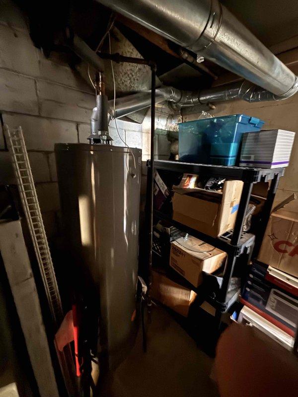 Conducted comprehensive assessment of existing HVAC system in basement utility area for full system replacement estimate. Evaluated current furnace unit with beige corrugated front panel and existing metallic ductwork configuration, including flexible and rigid duct connections. Documented equipment condition, installation layout, and spatial constraints in utility area shared with water heater and storage. Photographed existing system components and mechanical room setup to provide detailed replacement recommendations for both furnace and central air conditioning units, as customer requested immediate system replacement timeline.