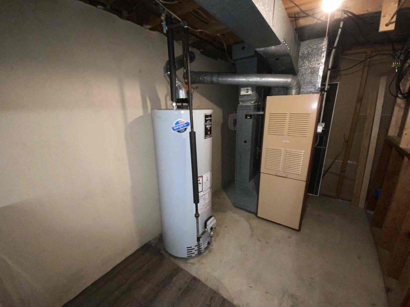 Completed on-site assessment for replacement estimate of existing basement-installed heating and cooling system serving medium-sized residential space of 1200-2000 square feet. Evaluated current natural gas furnace and associated ductwork configuration, documented equipment specifications, and photographed installation layout including existing water heater proximity and electrical panel location. Provided comprehensive replacement options for complete furnace and air conditioning system upgrade.