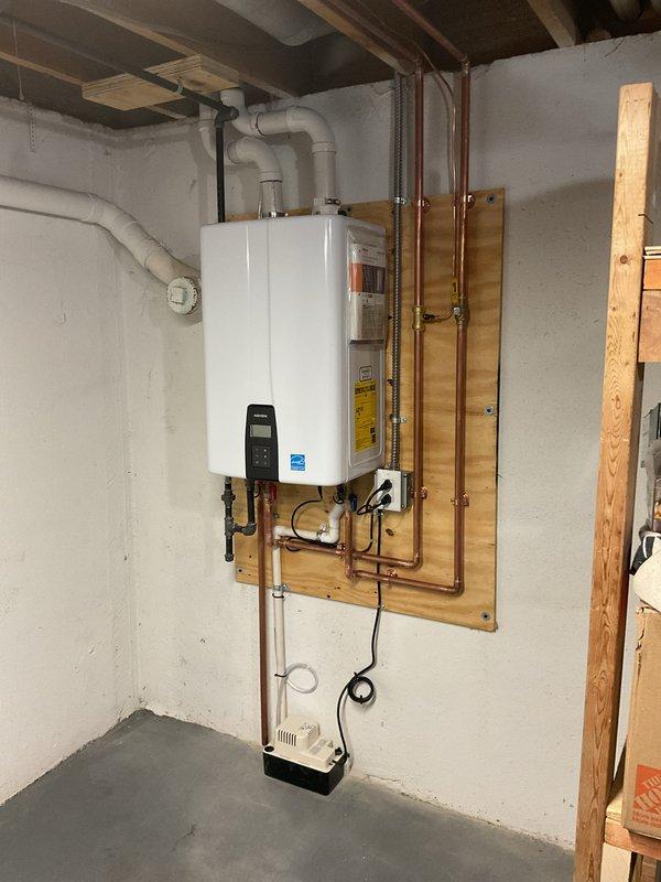 Completed full HVAC system installation including furnace, air conditioning unit, and tankless water heater. Installed wall-mounted tankless water heater in basement utility area with proper copper supply lines, PVC venting through exterior wall, and condensate pump for drainage. Configured exterior PVC exhaust and intake piping through brick foundation with proper termination and clearances. All equipment mounted securely, electrical connections completed, and system tested for proper operation.