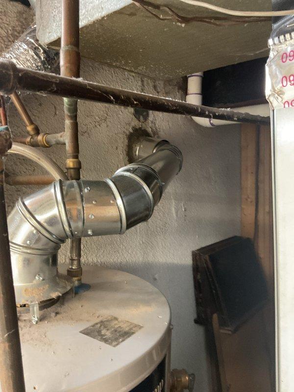 Completed chimney liner installation for water heater venting system. Dropped and secured stainless steel flexible liner through existing ceiling penetration, connected to water heater flue outlet with proper metal elbow fitting and securing bands. Verified proper draft and clearances per manufacturer specifications.