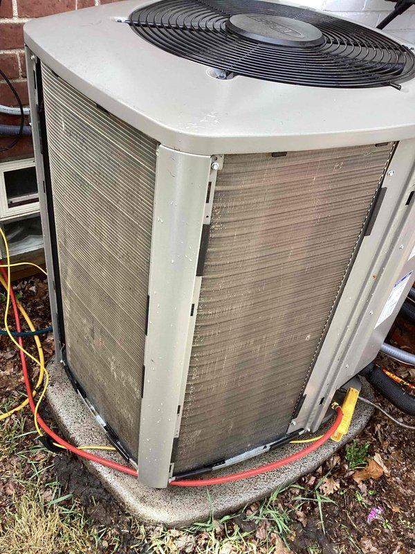 Responded to service call for thermostat displaying incorrect temperature readings on approximately one-year-old system. Upon arrival, verified heating and cooling functions were operational despite inaccurate temperature display at thermostat. Inspected outdoor condenser unit and found substantial dirt and debris accumulation on heat exchanger coils and cabinet surfaces, which can affect system efficiency and sensor accuracy. Documented unit condition with photographs showing compromised coil cleanliness and general weathering. Refrigerant lines with foam insulation appeared intact. System age and operational status confirmed with both thermostat and furnace at approximately one year of service.