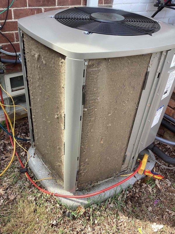 Responded to service call for thermostat displaying incorrect temperature readings on approximately one-year-old system. Upon arrival, verified heating and cooling functions were operational despite inaccurate temperature display at thermostat. Inspected outdoor condenser unit and found substantial dirt and debris accumulation on heat exchanger coils and cabinet surfaces, which can affect system efficiency and sensor accuracy. Documented unit condition with photographs showing compromised coil cleanliness and general weathering. Refrigerant lines with foam insulation appeared intact. System age and operational status confirmed with both thermostat and furnace at approximately one year of service.