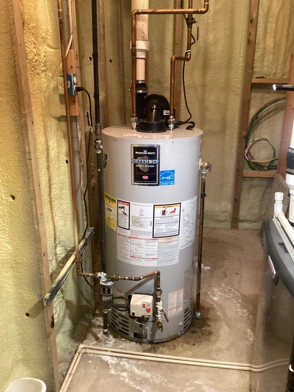 Completed annual cooling maintenance on residential HVAC system. Replaced air filter and evaporator pad as requested. Inspected and photographed water heater installation in utility area, noting proper Bradford White Defender unit operation with functional safety systems, appropriate copper piping connections, and adequate spray foam insulation throughout mechanical room.