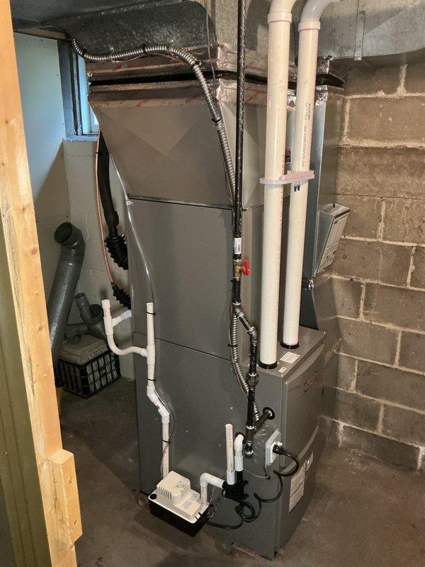 Completed full HVAC system installation including a 70,000 BTU furnace with liner and 2.5-ton air conditioning unit configured for right-side placement. Installed all necessary PVC venting and drainage piping with proper routing and support brackets, connected electrical conduit, and integrated unit with existing ductwork. Performed system reconnection and ensured all mechanical components were properly secured and operational in basement utility room.