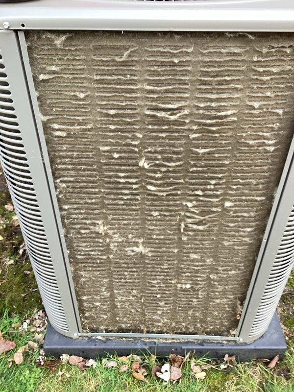 Completed comprehensive Air Care heating and cooling maintenance service on residential HVAC system. Performed seasonal inspection of outdoor air conditioning unit, which exhibited significant filter and coil contamination requiring thorough cleaning. Addressed heavily soiled condenser with accumulated dirt, dust, and debris buildup on exterior panels and ventilation components. Inspected indoor furnace unit with access panel removed to evaluate internal components including blower motor assembly, gas connections, refrigerant lines, electrical wiring harnesses, and condensate drain system. Verified proper operation of all mechanical and electrical systems. Brought replacement humidifier pad as noted in service call prerequisites to ensure optimal indoor air quality during heating season.