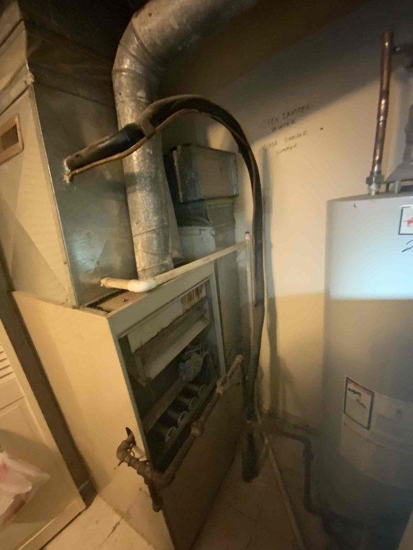 Completed estimate for replacement of 25-year-old furnace system. Inspected existing equipment in basement utility area, documented current furnace condition with access panel open to assess internal components and wiring configuration. Evaluated ductwork connections and overall HVAC system layout. Assessed exterior condenser unit showing significant age-related wear and weathering. Provided replacement options and discussed BOGO promotion availability for expedited installation scheduling.
