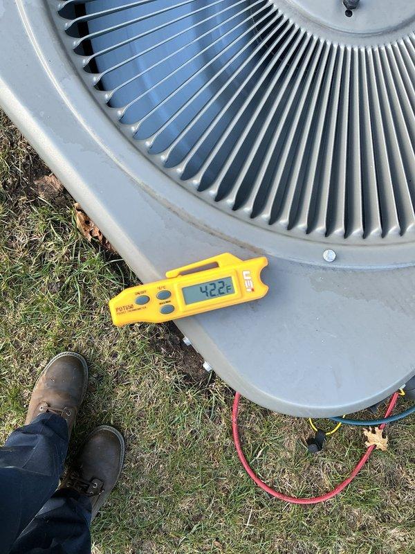 Performed comprehensive preventive maintenance on a three-year-old central air conditioning system located at a mobile home residence. Conducted complete AC tune-up including inspection of outdoor condenser unit, verification of electrical connections at disconnect box, measurement of system operating parameters using digital diagnostic equipment (recorded reading of 422), and thorough examination of refrigerant lines running to the structure. System was found operating properly with no deficiencies noted. All components including condenser fan, louvered panels, and mounting pad were inspected and determined to be in good working condition with normal wear appropriate for unit age.