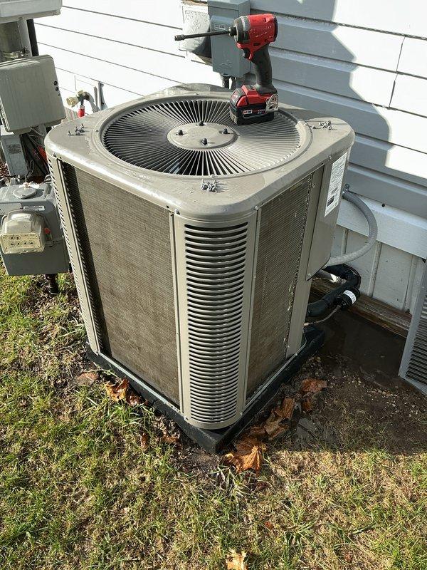 Performed comprehensive preventive maintenance on a three-year-old central air conditioning system located at a mobile home residence. Conducted complete AC tune-up including inspection of outdoor condenser unit, verification of electrical connections at disconnect box, measurement of system operating parameters using digital diagnostic equipment (recorded reading of 422), and thorough examination of refrigerant lines running to the structure. System was found operating properly with no deficiencies noted. All components including condenser fan, louvered panels, and mounting pad were inspected and determined to be in good working condition with normal wear appropriate for unit age.