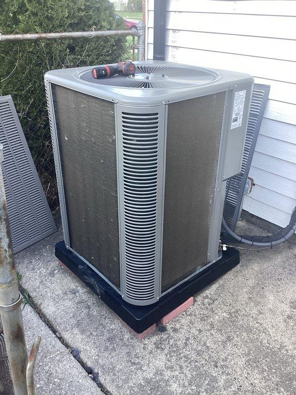 Completed annual maintenance on residential split system air conditioning unit. Performed comprehensive inspection of outdoor condenser including cleaning of coils, verification of refrigerant levels, electrical connections check, and operational testing of compressor and fan motor. Unit found in good working condition with normal wear patterns. Documented equipment condition with photos showing proper installation on pad with appropriate clearances and functioning components.