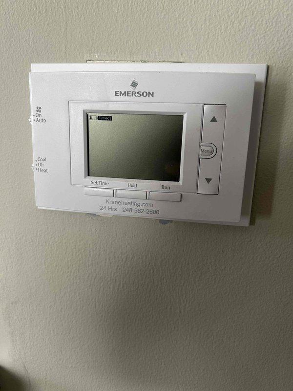 Responded to no heat call and diagnosed non-functional Emerson programmable thermostat. Upon inspection, found thermostat display blank and unresponsive to input commands. Verified Goodman furnace unit operational and determined thermostat failure as root cause of heating system malfunction.