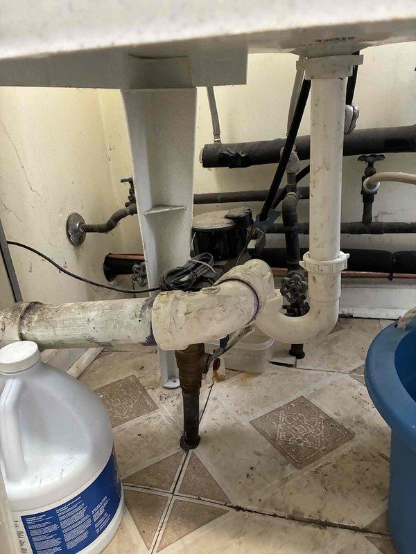 Responded to a plumbing repair call for a disconnected drain pipe located beneath the washing machine sink. Upon arrival, assessed the existing PVC P-trap assembly which had become separated at a connection point, causing drainage issues that had persisted for approximately 30 days. Reconnected and secured the white PVC drainage piping, ensuring proper alignment and sealing of all joints within the P-trap configuration. Tested the drain system for proper flow and verified no leaks were present at connection points following repair completion.