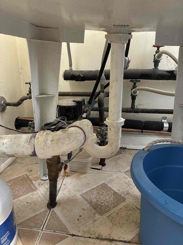 Responded to a plumbing repair call for a disconnected drain pipe located beneath the washing machine sink. Upon arrival, assessed the existing PVC P-trap assembly which had become separated at a connection point, causing drainage issues that had persisted for approximately 30 days. Reconnected and secured the white PVC drainage piping, ensuring proper alignment and sealing of all joints within the P-trap configuration. Tested the drain system for proper flow and verified no leaks were present at connection points following repair completion.