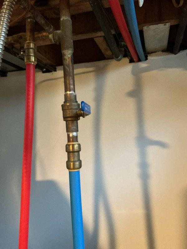 # Tanked Water Heater Maintenance Service

Performed comprehensive drain, clean, and flush service on tanked water heater located in basement. Accessed unit through exposed plumbing infrastructure and executed complete sediment removal procedure to restore optimal heating efficiency and extend equipment lifespan. Inspected surrounding plumbing connections, including hot water supply lines (red PEX), cold water supply lines (blue PEX with ball valve), and brass fittings for proper operation and potential issues. All isolation valves and connections were verified to be functioning correctly. Water heater tank showed normal wear patterns consistent with standard residential use. Flushing procedure successfully removed accumulated mineral deposits and sediment buildup from tank bottom. System was refilled, tested for proper operation, and confirmed to be heating efficiently with no leaks detected at any connection points.