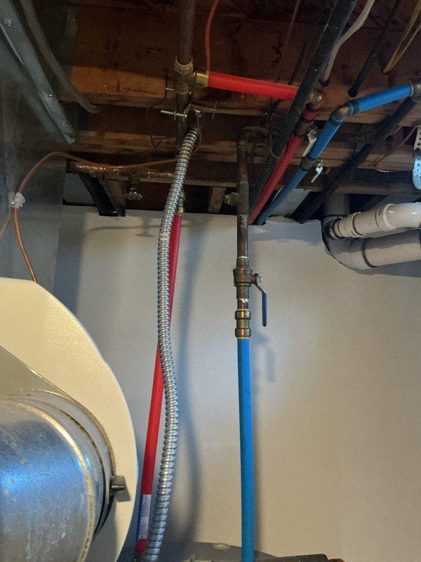 # Tanked Water Heater Maintenance Service

Performed comprehensive drain, clean, and flush service on tanked water heater located in basement. Accessed unit through exposed plumbing infrastructure and executed complete sediment removal procedure to restore optimal heating efficiency and extend equipment lifespan. Inspected surrounding plumbing connections, including hot water supply lines (red PEX), cold water supply lines (blue PEX with ball valve), and brass fittings for proper operation and potential issues. All isolation valves and connections were verified to be functioning correctly. Water heater tank showed normal wear patterns consistent with standard residential use. Flushing procedure successfully removed accumulated mineral deposits and sediment buildup from tank bottom. System was refilled, tested for proper operation, and confirmed to be heating efficiently with no leaks detected at any connection points.