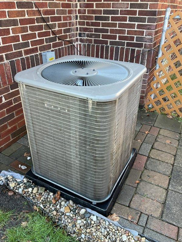 Completed ComfortGuard preventive maintenance service on residential outdoor air conditioning condenser unit. Performed comprehensive AC/coil only maintenance protocol including visual inspection of cabinet condition, verification of proper unit placement on equipment pad, assessment of airflow clearances around all sides of the condenser, and examination of top discharge grille and fan assembly. Unit found to be in serviceable condition with normal weathering consistent with outdoor installation. Condenser positioned appropriately on protective pad with adequate drainage and clearance from surrounding structures. All accessible components inspected and system ready for cooling season operation.