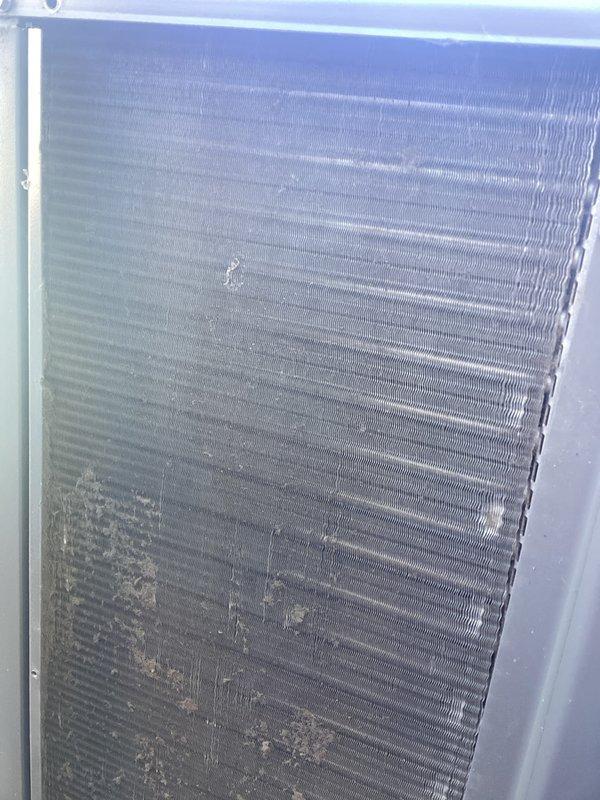 Completed annual cooling maintenance on outdoor HVAC unit. Inspected and cleaned heavily clogged air filter screen showing significant accumulation of dirt, dust, debris, and organic matter that was restricting airflow. Cleaned condenser coil fins which displayed substantial dirt buildup, discoloration, and debris accumulation across lower section that would impede heat transfer efficiency. Verified proper operation of unit following cleaning procedures.