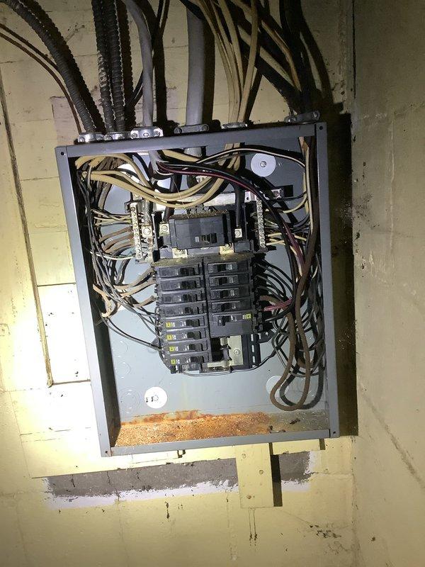 Completed comprehensive whole home electrical inspection. Documented electrical panel condition, noting corrosion debris accumulation at bottom of enclosure requiring attention. Assessed basement electrical infrastructure including exposed wiring, conduit routing, and overall system integrity in moisture-prone environment with evidence of water intrusion on surrounding masonry surfaces.