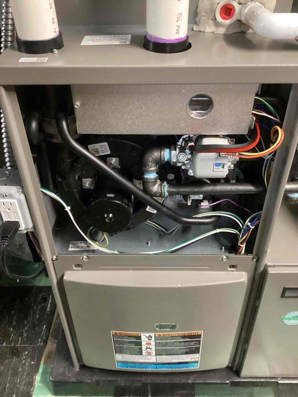 Responded to service call for furnace vibrating the floor in living room and condensate pump tripping GFCI outlet. Performed comprehensive inspection of furnace system with access panels removed to assess internal components, mounting hardware, and mechanical assemblies. Inspected blower motor, electrical connections, condensate pump operation, and all associated piping and drainage systems. Documented system conditions with photographs for service records as part of recurring Air Care Heating and Cooling maintenance program.