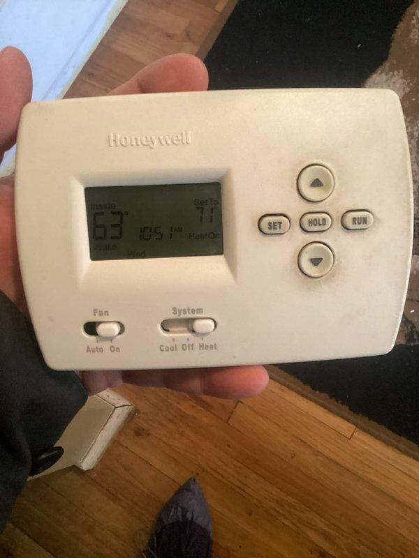 Responded to no-heat call on 11+ year old furnace system located in basement. Upon arrival, found Honeywell programmable thermostat displaying low battery warning message. Removed thermostat from wall mount and replaced depleted batteries. Verified thermostat display restored to proper function showing heat call at 71-degree setpoint with current temperature reading of 53 degrees. Confirmed system communication restored and heating cycle initiated successfully.