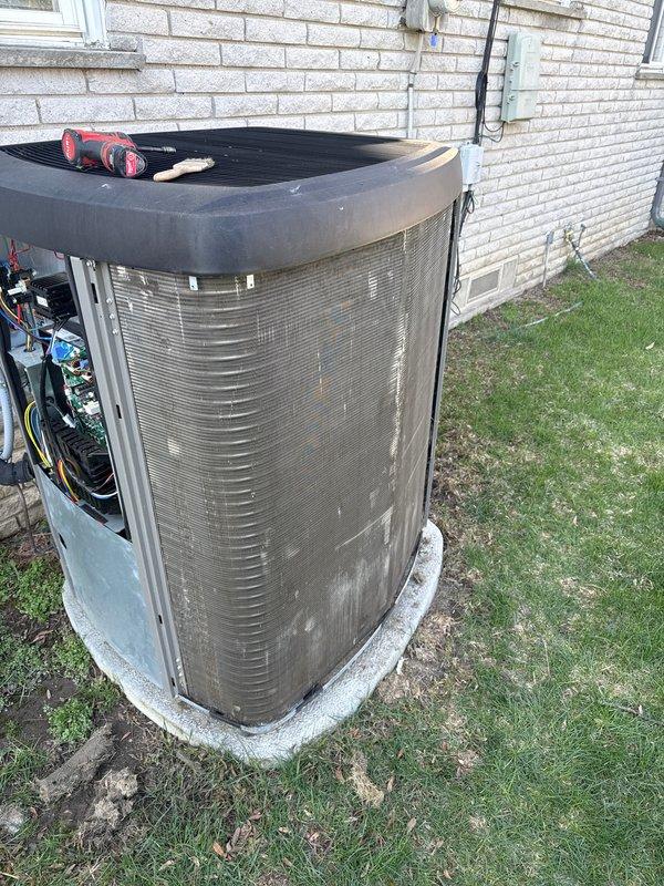 Completed annual cooling maintenance on residential outdoor condensing unit. Removed and inspected access panels, revealing heavily soiled air filter with significant dirt and debris accumulation. Cleaned filter screen, inspected electrical connections and wiring for proper operation, verified refrigerant lines and internal components. Unit restored to operational condition with all panels secured and system tested for proper function.