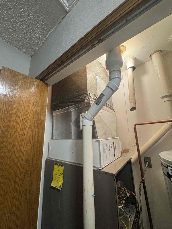 Conducted comprehensive full system replacement estimate for a medium-sized residential property (1200-2000 sq ft) with existing 15-year-old natural gas furnace and 16-year-old air conditioning system located in utility closet. Assessed current gray metal furnace unit with PVC venting, evaluated ductwork configuration, and inspected electrical connections and gas line accessibility. Documented equipment placement constraints in mechanical room shared with water heater, photographed existing installation including copper refrigerant lines and condensate drainage setup. Provided replacement options for combined heating and cooling system utilizing natural gas energy source, discussed crawlspace unit placement considerations, and reviewed available financing solutions for complete HVAC system upgrade to improve efficiency and reliability for homeowner seeking replacement within current season.