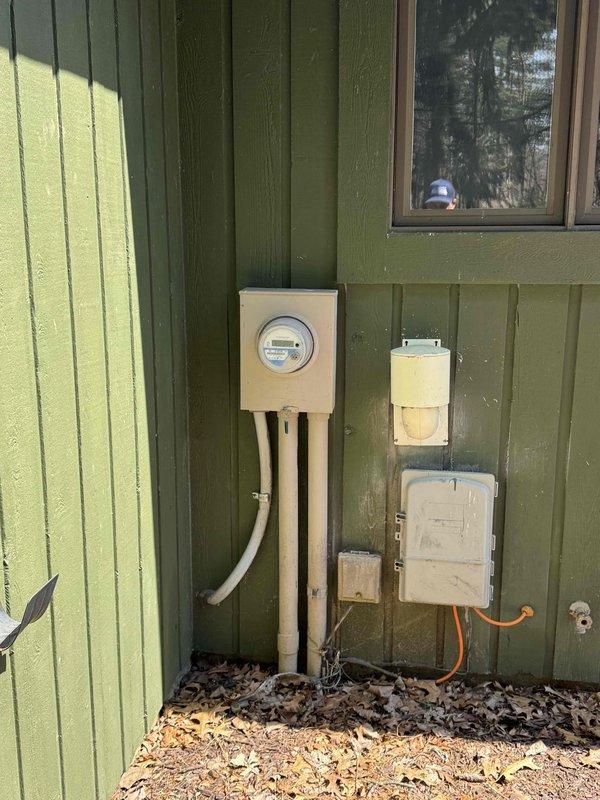 Provided estimate for complete HVAC system replacement including furnace and air conditioner under BOGO promotion for basement-installed equipment dating from 2006. Non-functional air conditioning unit and aging furnace require replacement, with exterior condenser unit accessible via narrow side yard passage adjacent to existing electrical service and gas lines.