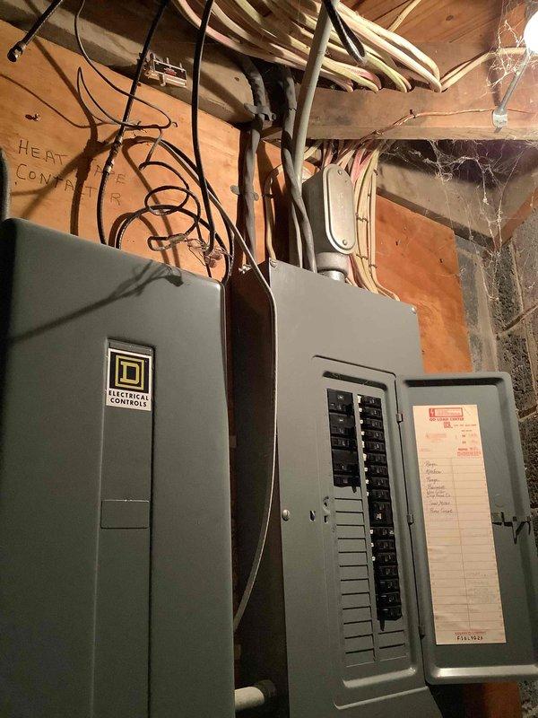 Conducted on-site electrical assessment for standby generator installation at residential property with no existing backup power system. Evaluated current electrical service configuration, including main distribution panels in basement utility area and exterior meter installation. Documented existing 200-amp service with dual panel setup and exterior meter mounted on brick/siding junction. Assessed available space for generator placement, transfer switch installation requirements, and necessary electrical connections to integrate automatic standby power system. Photographed electrical infrastructure to support equipment sizing and installation planning for whole-house generator solution.