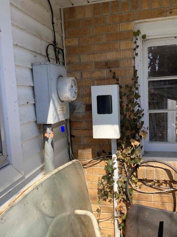 Conducted on-site electrical assessment for standby generator installation at residential property with no existing backup power system. Evaluated current electrical service configuration, including main distribution panels in basement utility area and exterior meter installation. Documented existing 200-amp service with dual panel setup and exterior meter mounted on brick/siding junction. Assessed available space for generator placement, transfer switch installation requirements, and necessary electrical connections to integrate automatic standby power system. Photographed electrical infrastructure to support equipment sizing and installation planning for whole-house generator solution.