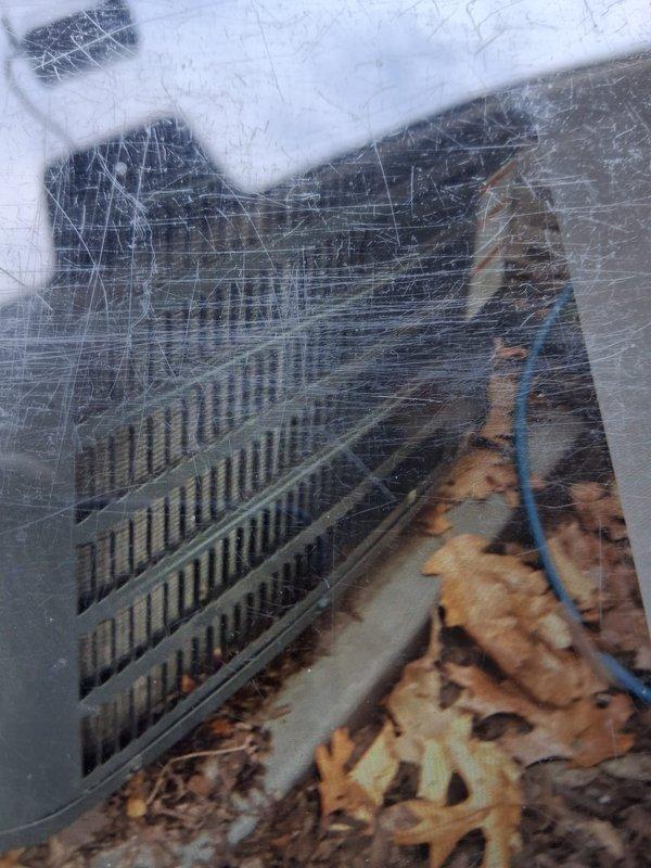 Completed scheduled maintenance on air conditioning system. Inspected evaporator coil through access panel, noting significant surface wear on return air grate and rust-colored staining present in drain pan area, indicating potential condensate drainage concerns. Documented equipment condition with photos showing triangular A-coil configuration with visible fin deterioration and debris accumulation at outdoor air intake requiring attention during next service interval.