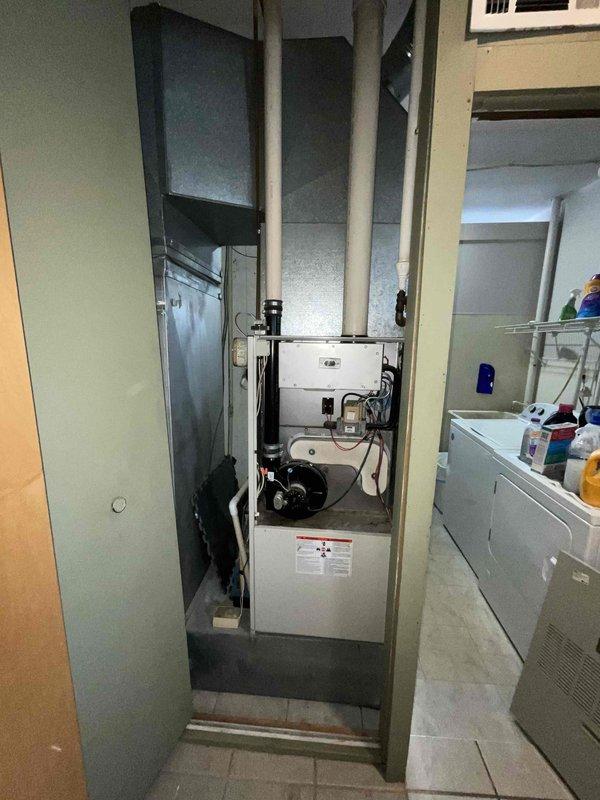 Completed estimate for furnace replacement on aging residential heating system over 20 years old located in basement utility area. Assessed existing furnace unit with beige metal cabinet, associated ductwork, and PVC venting system. Documented current equipment configuration including air handler placement and mechanical room layout for replacement proposal.