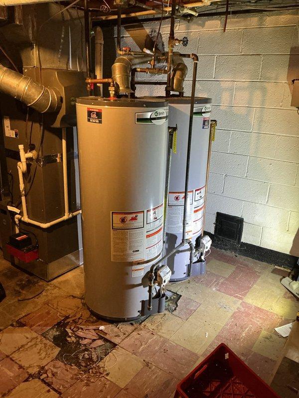 # HVAC Maintenance - ACM Completed

Performed routine air conditioning maintenance inspection on residential cooling system. Accessed basement mechanical room to evaluate HVAC equipment and associated plumbing infrastructure. Inspected furnace/air handler unit with connected ductwork, verified proper operation of cooling components, and examined mechanical systems integration with water heating equipment in shared utility space.

Evaluated plumbing connections serving HVAC system, including copper piping, galvanized metal pipes, and various shut-off valves with blue and red handles. Inspected complex pipe assembly with multiple fittings, joints, and connections showing normal aging patina on copper surfaces. Verified integrity of pipe mounting hardware secured to ceiling joists and confirmed proper support of vertical and horizontal pipe runs.

Documented facility conditions including floor surface wear patterns and general maintenance status of mechanical room. Noted presence of debri