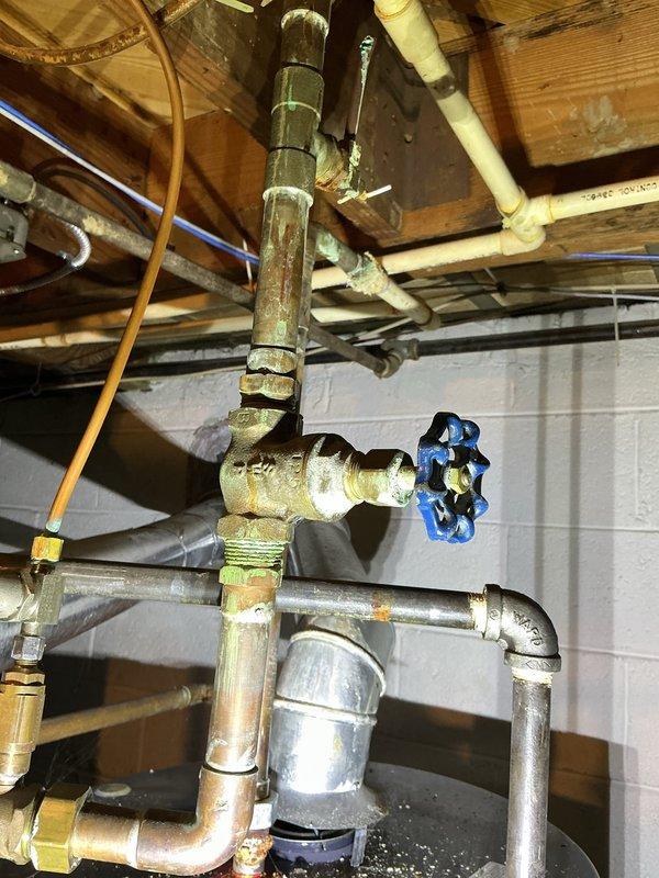 # HVAC Maintenance - ACM Completed

Performed routine air conditioning maintenance inspection on residential cooling system. Accessed basement mechanical room to evaluate HVAC equipment and associated plumbing infrastructure. Inspected furnace/air handler unit with connected ductwork, verified proper operation of cooling components, and examined mechanical systems integration with water heating equipment in shared utility space.

Evaluated plumbing connections serving HVAC system, including copper piping, galvanized metal pipes, and various shut-off valves with blue and red handles. Inspected complex pipe assembly with multiple fittings, joints, and connections showing normal aging patina on copper surfaces. Verified integrity of pipe mounting hardware secured to ceiling joists and confirmed proper support of vertical and horizontal pipe runs.

Documented facility conditions including floor surface wear patterns and general maintenance status of mechanical room. Noted presence of debri