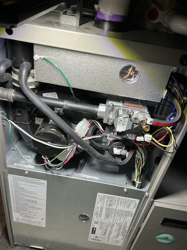 Completed comprehensive Air Care heating and cooling maintenance service on residential HVAC system. Performed full inspection of furnace unit with access panel removal, examining gas valve assembly, heat exchanger, and blower housing components. Verified proper operation of electronic gas valve controls and checked all electrical connections including multi-colored wire harnesses and safety circuits. Inspected gas line connections, rubber hoses, and flexible tubing for wear or deterioration. Confirmed all manufacturer specifications and regulatory compliance labels were present and legible. System components found to be clean, well-maintained, and operating within normal parameters.
