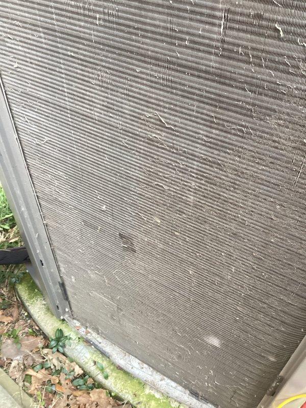 # HVAC Maintenance - ACM Completed

Performed scheduled preventive maintenance on residential air conditioning condenser unit. Upon arrival, conducted visual inspection which revealed heavily soiled condenser coils with significant accumulation of dirt, debris, and organic matter throughout the fin surfaces. Multiple fins displayed bent and damaged sections, particularly in upper areas of the heat exchanger.

Documented pre-service condition with photographs showing extensive contamination on both exterior and interior coil surfaces, including cobwebs, dust buildup, and environmental debris lodged between fin spaces. Ground-level vegetation and algae growth were noted around unit base, indicating prolonged exposure without recent servicing.

Proceeded with comprehensive coil cleaning using appropriate cleaning solutions and equipment to remove accumulated dirt and restore heat transfer efficiency. Addressed clogged fin spaces to improve airflow through the heat exchanger. Straightened 